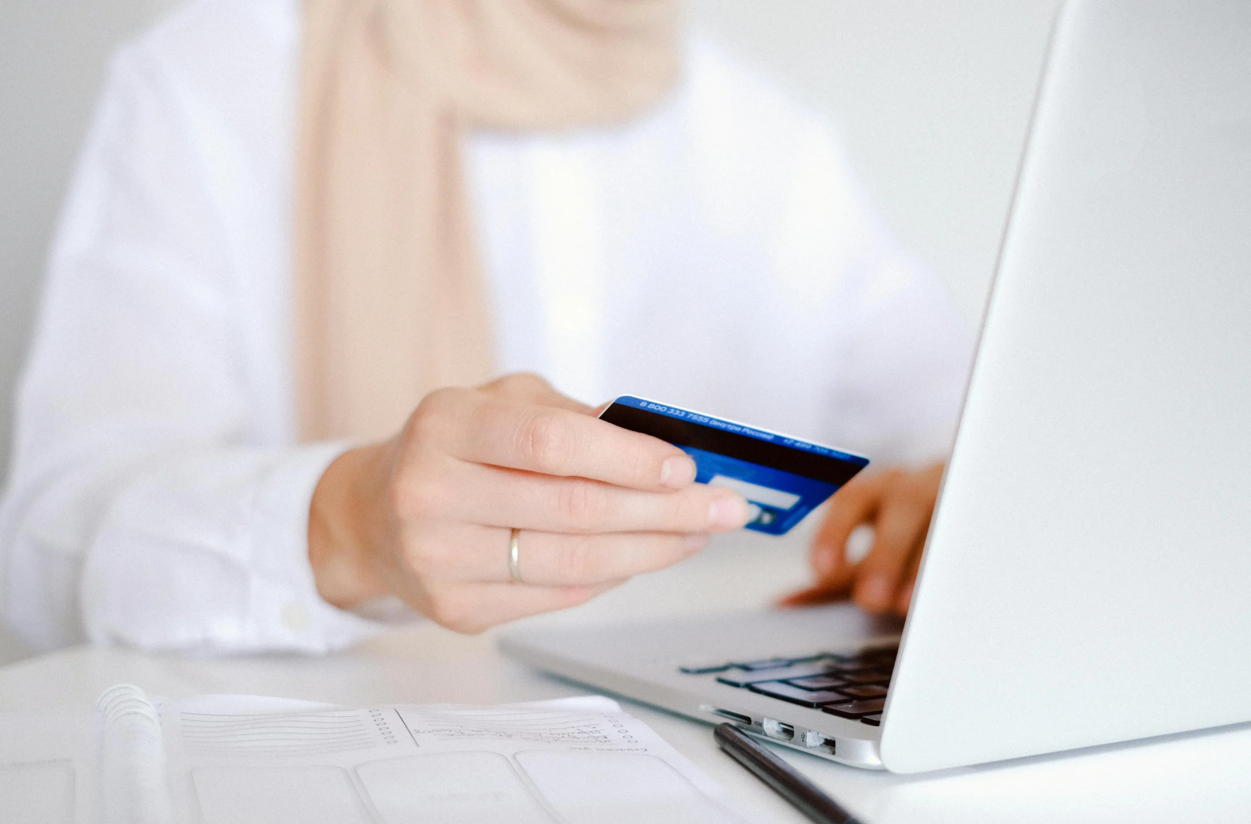 529A ABLE account — Close-up of a person holding a credit card while using a laptop for online shopping.