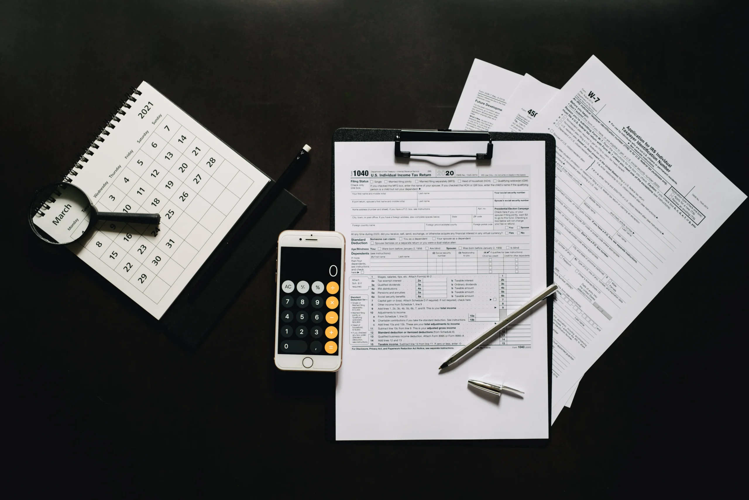 backdoor Roth IRA 2026: Flat lay of financial tools for tax preparation including forms, calculator, and calendar