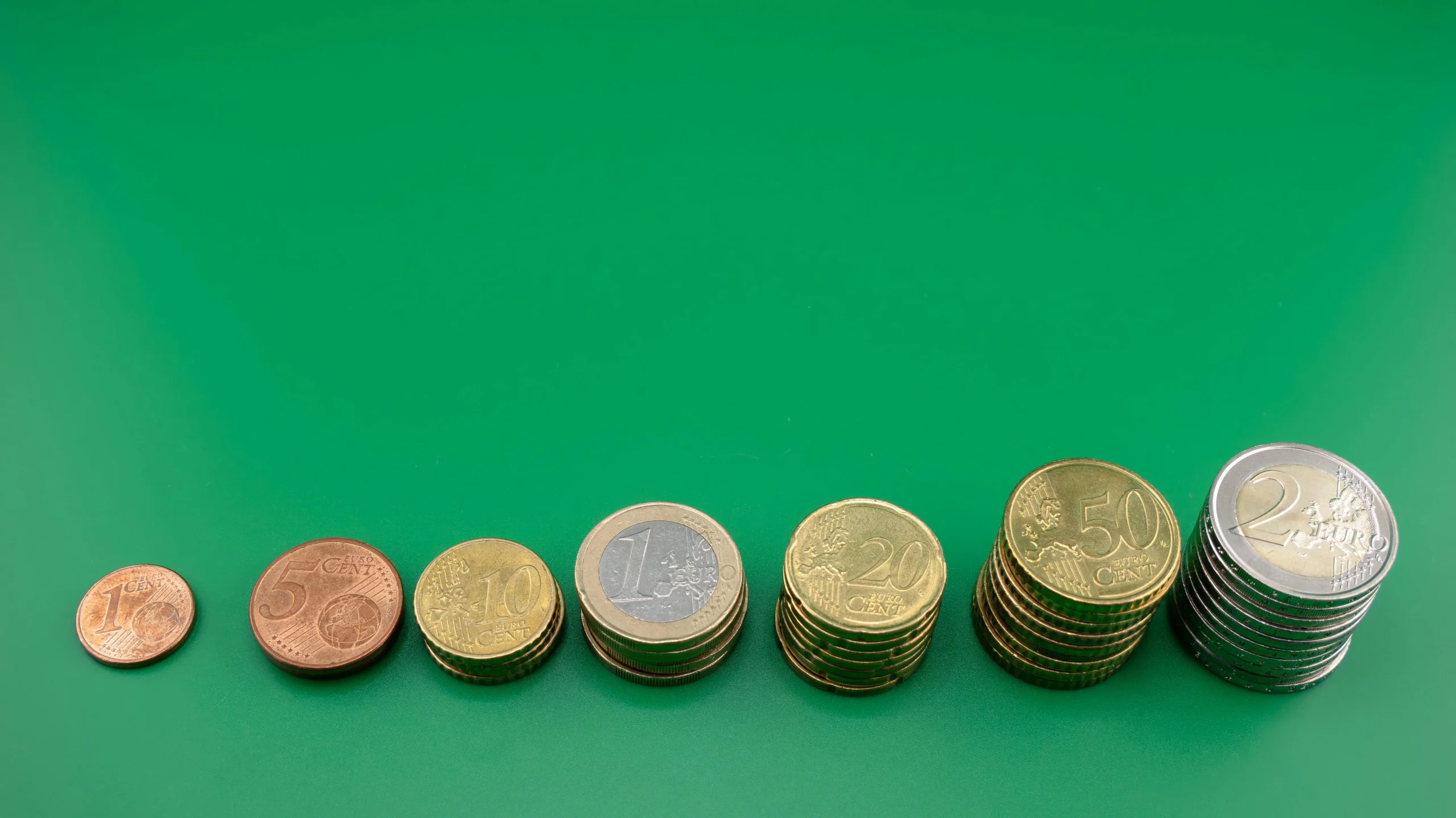 bond ladder strategy 2026: Various euro coins stacked incrementally on a vibrant green background