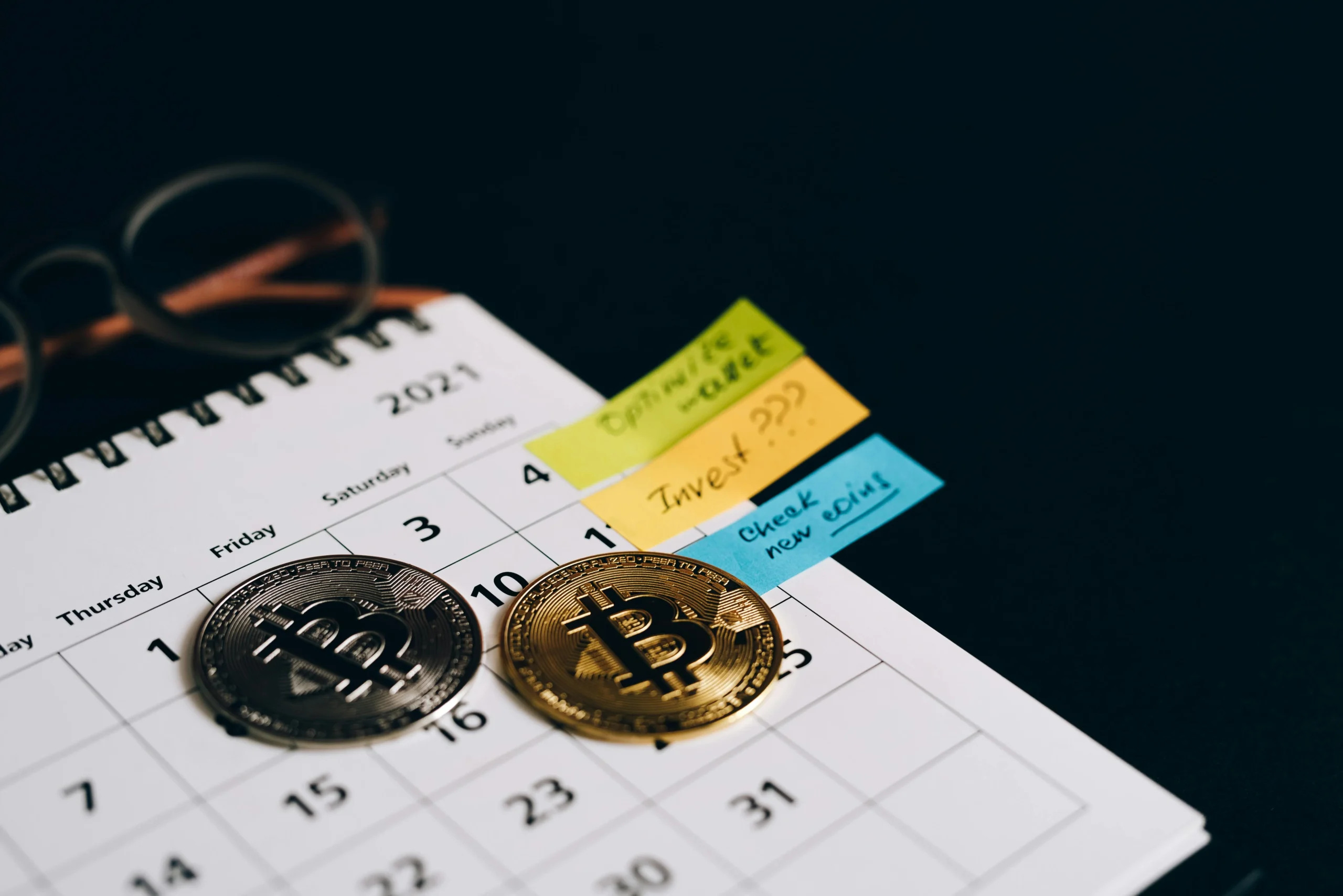 capital gains tax 2026: Bitcoin coins placed on a calendar with sticky notes for investment planning