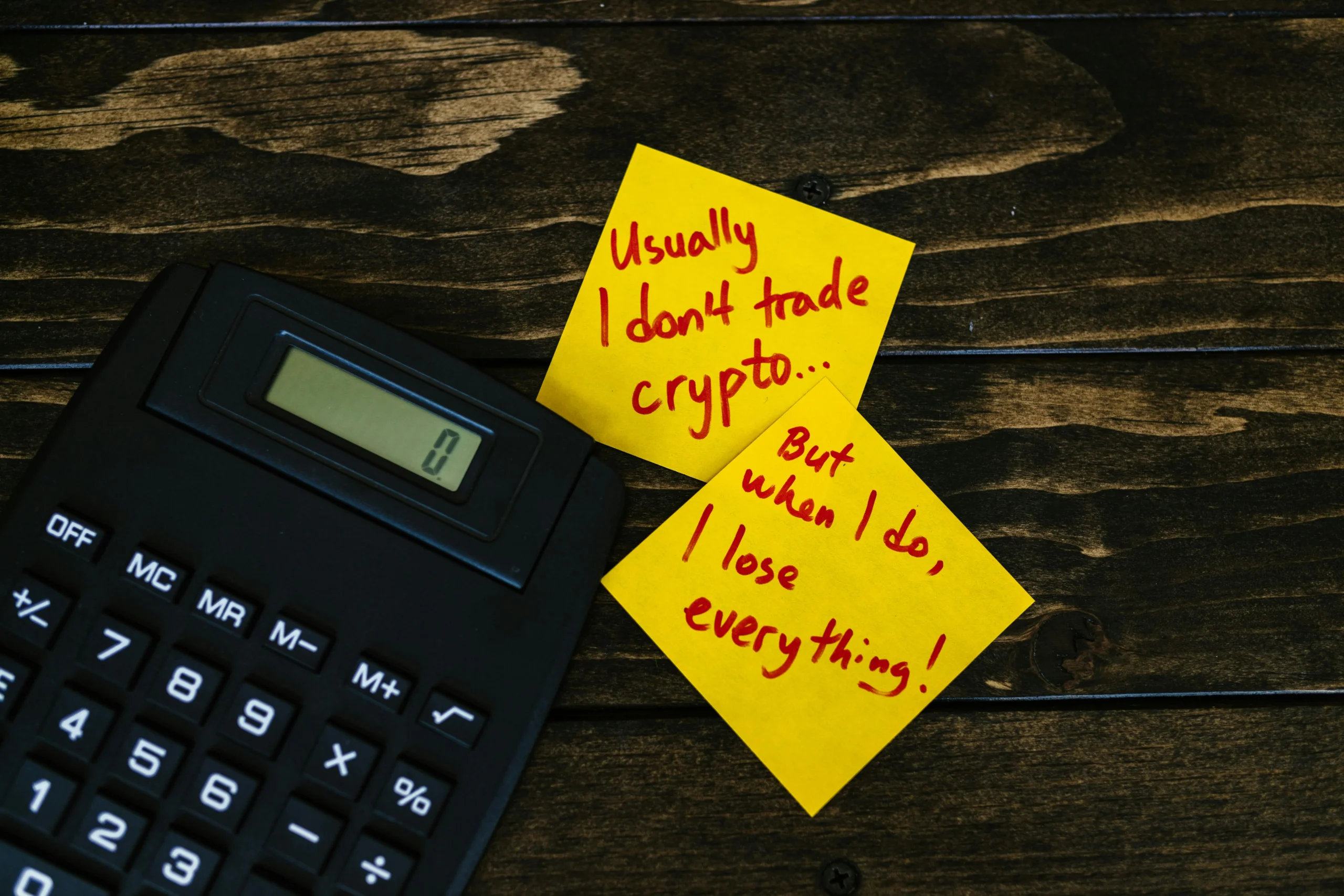 crypto bonus — Funny sticky notes about cryptocurrency trading with calculator on wooden table.