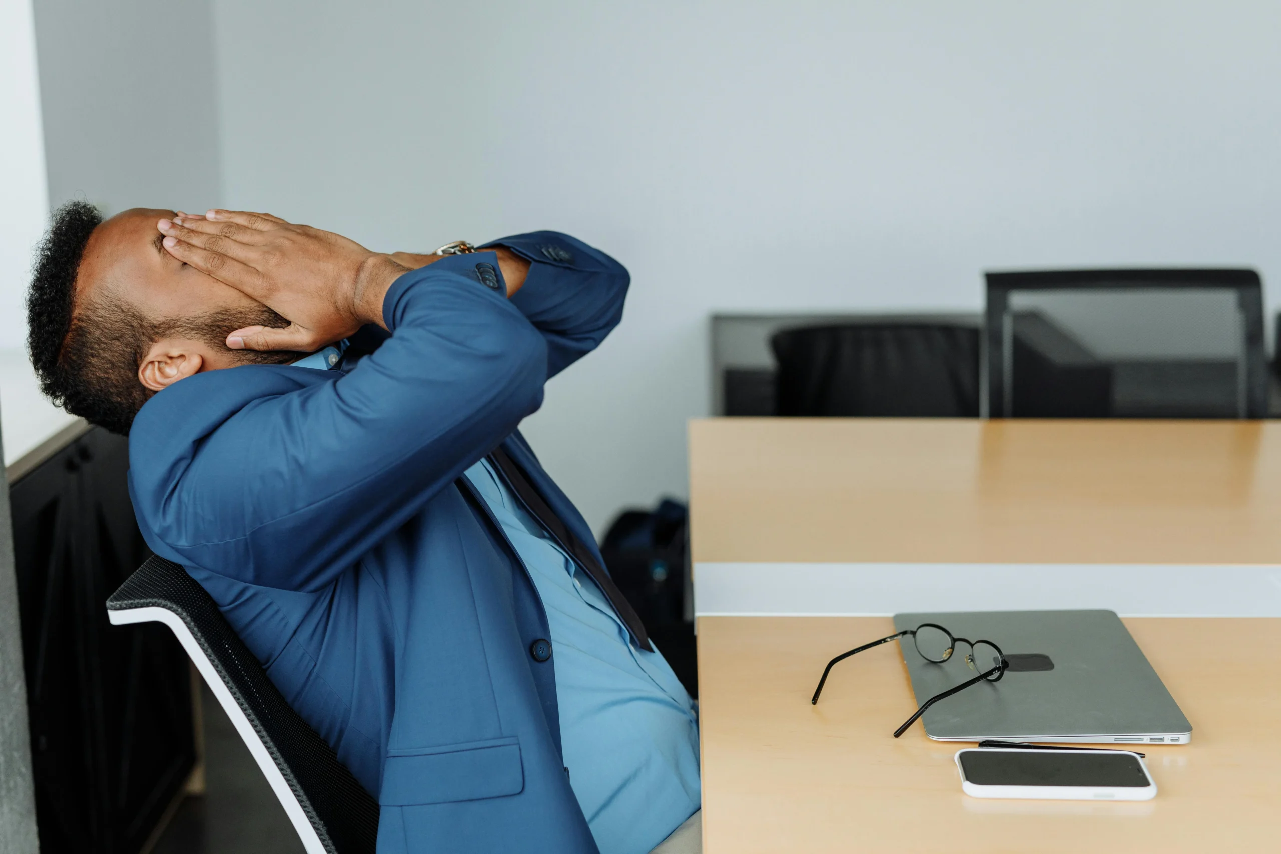 Disability Insurance High Earners 2026: 7 Essential Secrets 2 disability insurance high earners 2026: A stressed businessman in a suit covers his face while sitting at a desk with office