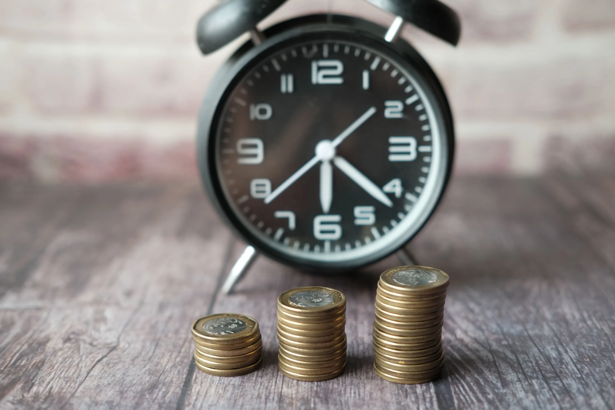 backdoor Roth IRA 2026: Stacked coins and a classic alarm clock symbolize the value of time and money