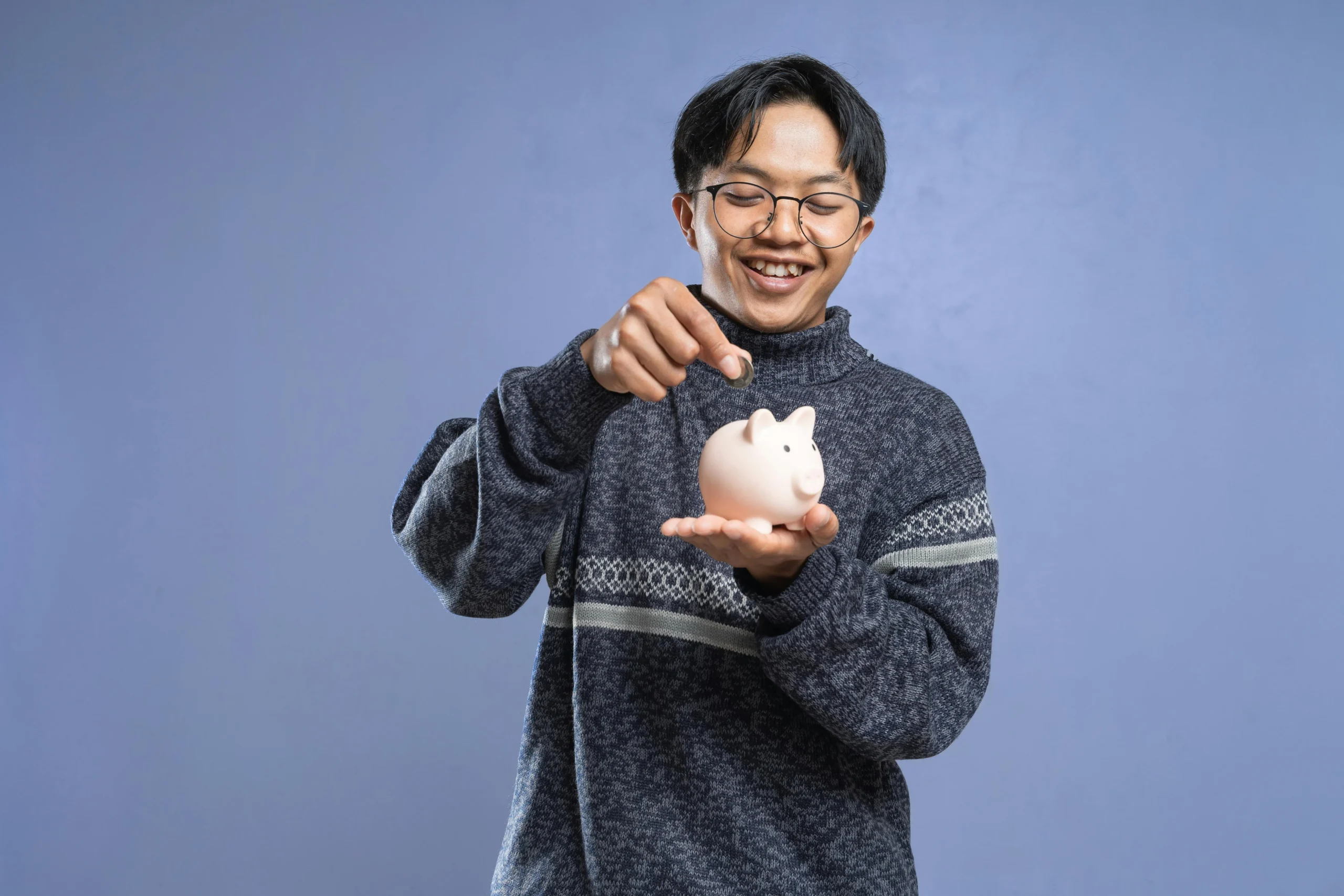 student loan buyback program 2026: Smiling man holding a piggy bank and inserting a coin, representing savings and financial