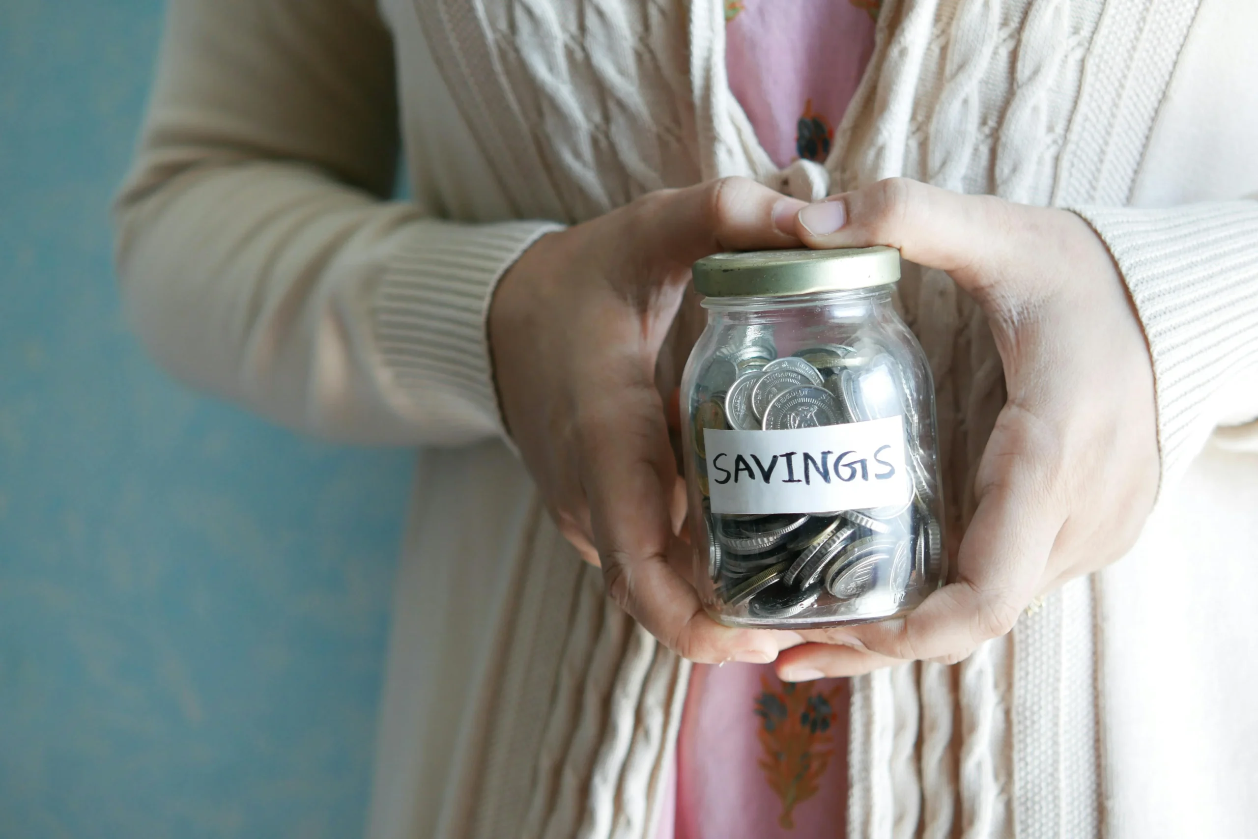 Tax Efficient ETF Portfolio 2026: Ultimate 7-Step Guide 1 tax efficient ETF portfolio 2026: Woman holding a jar labeled 'savings' filled with coins, representing financial savings