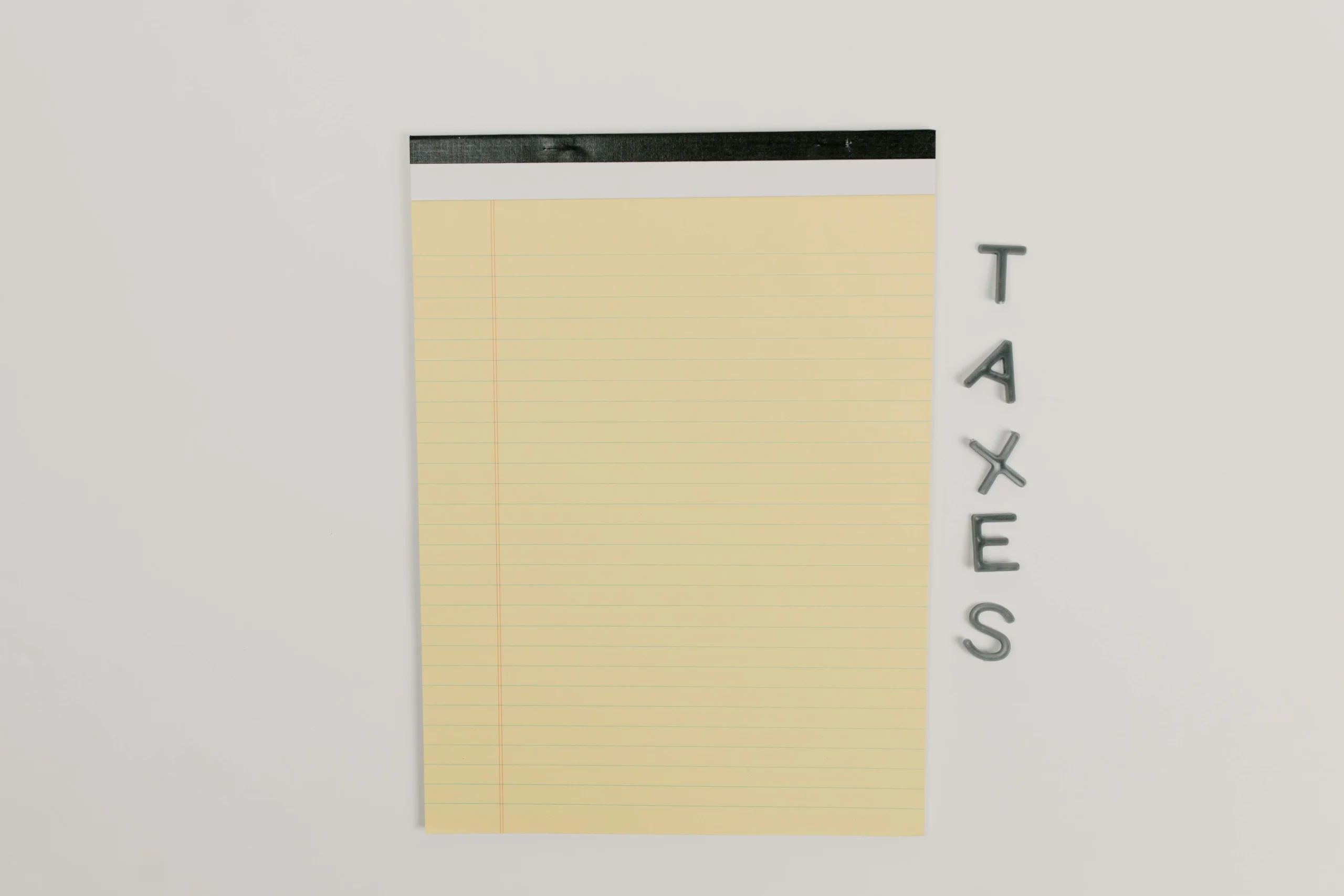 Medicare IRMAA 2026 brackets: Close-up of a yellow legal pad and the word 'TAXES' on a white surface, ideal for finance theme