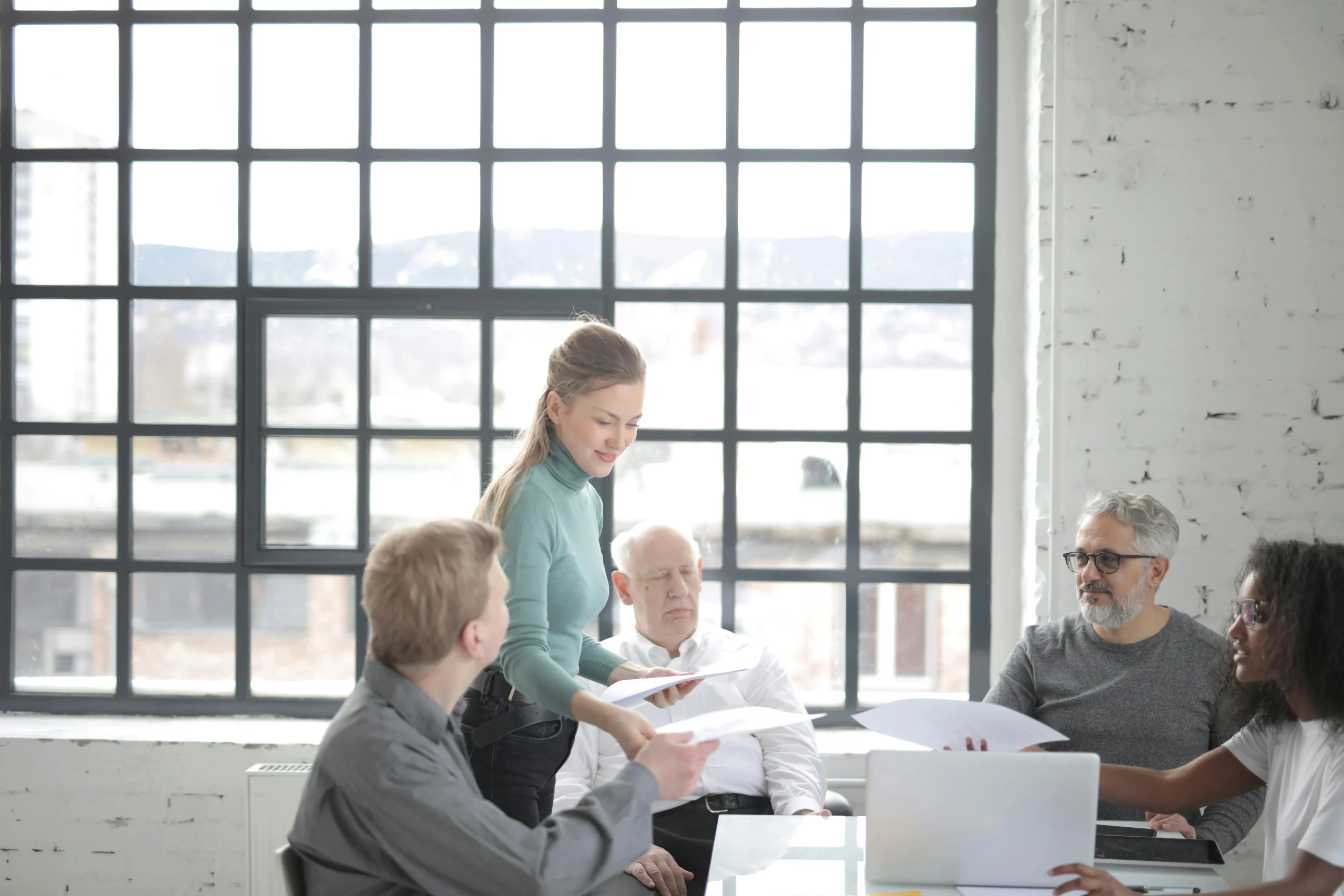 mega backdoor Roth 401k 2026: Multiracial coworkers of different ages in casual clothes discussing work plan and current issu
