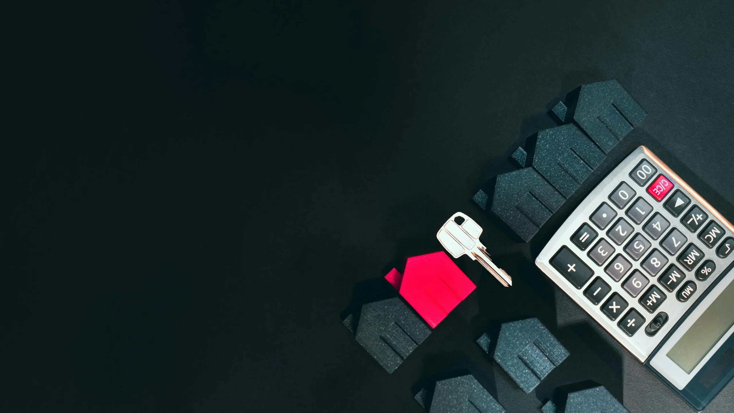 mortgage recast vs refinance 2026: Real estate concept image featuring a calculator, houses, and a key on a black background
