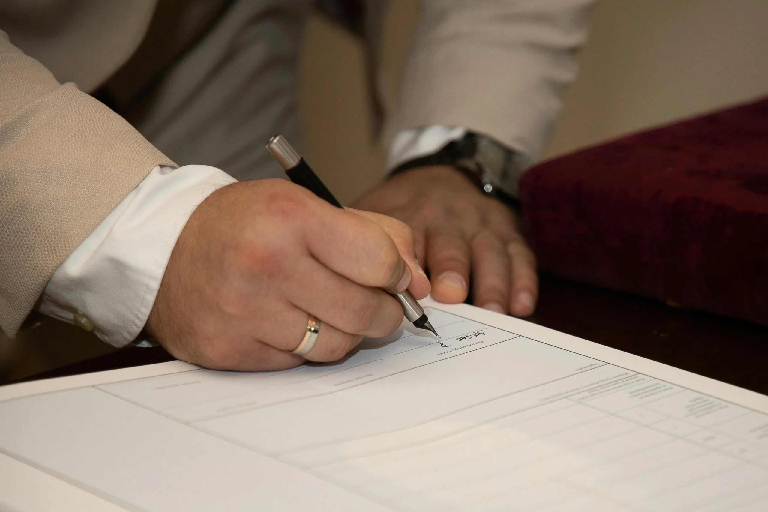 Qualified Charitable Distributions 2026: 7 Proven Ways 3 qualified charitable distributions 2026: A close-up of a man signing a document, showcasing a wedding ring and pen