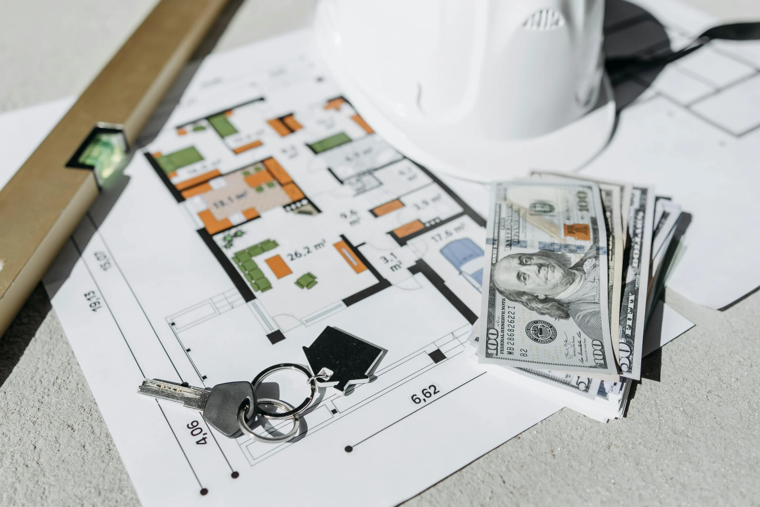 Roth conversion ladder 2026: Floor plan with cash, keys, and hard hat symbolizing real estate investment and property plannin