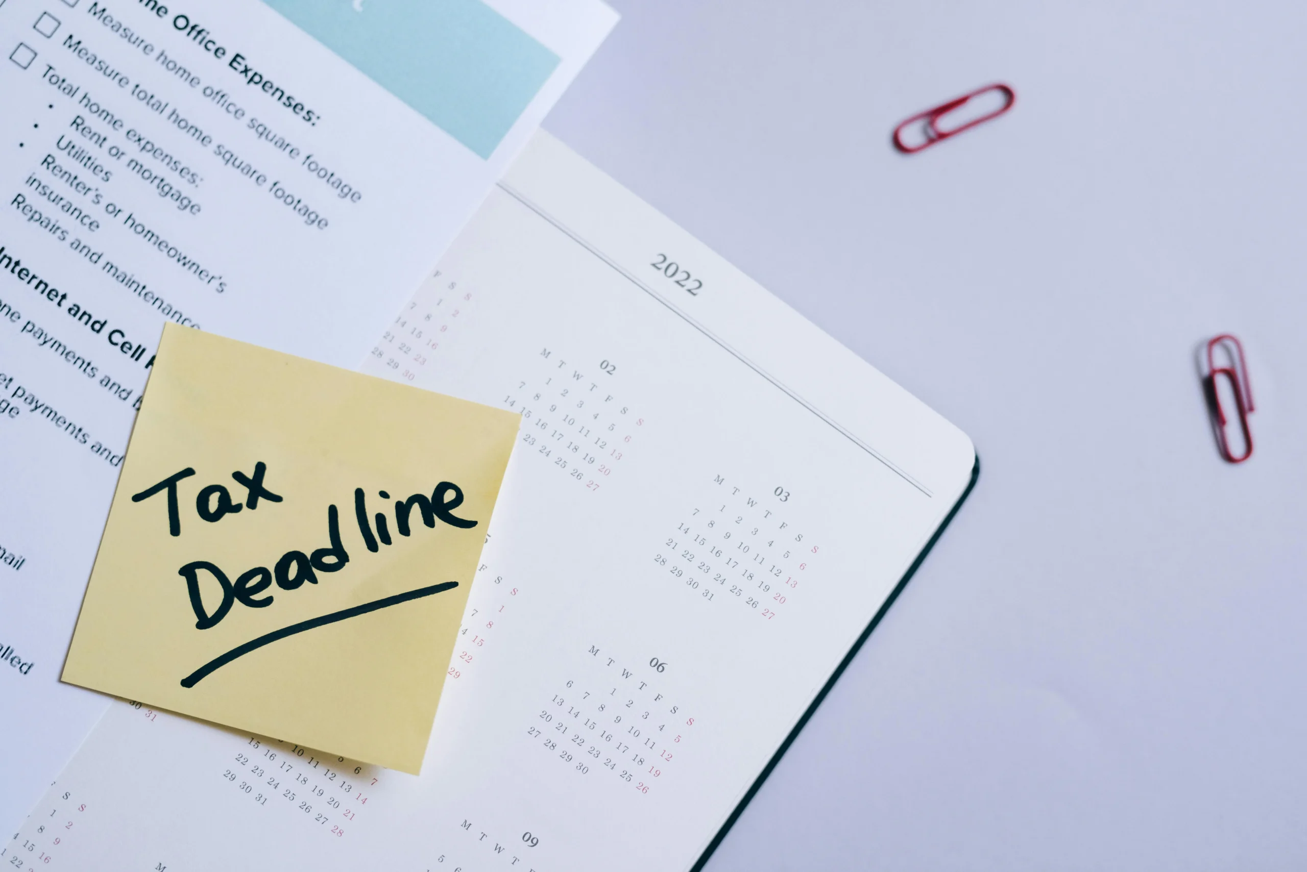 Roth conversion ladder 2026: A sticky note highlights tax deadline on a calendar alongside documents, emphasizing financial p