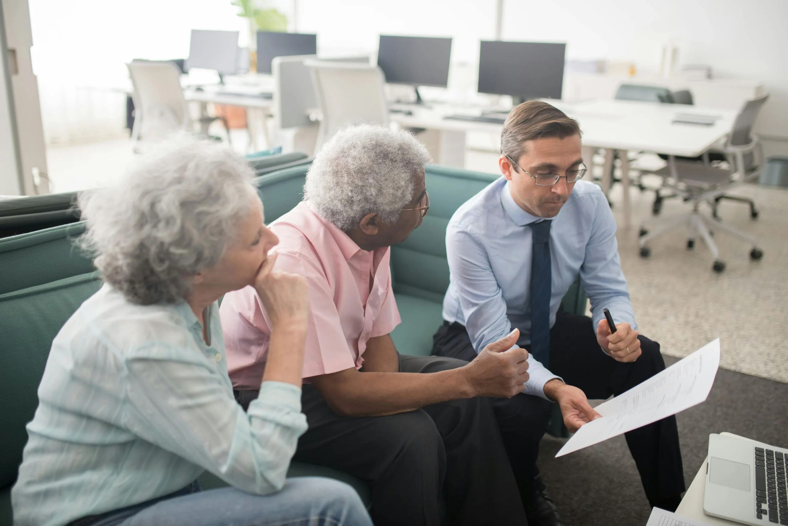 student loan buyback program 2026: Business professional consults elderly clients in an office setting. Collaborative discuss